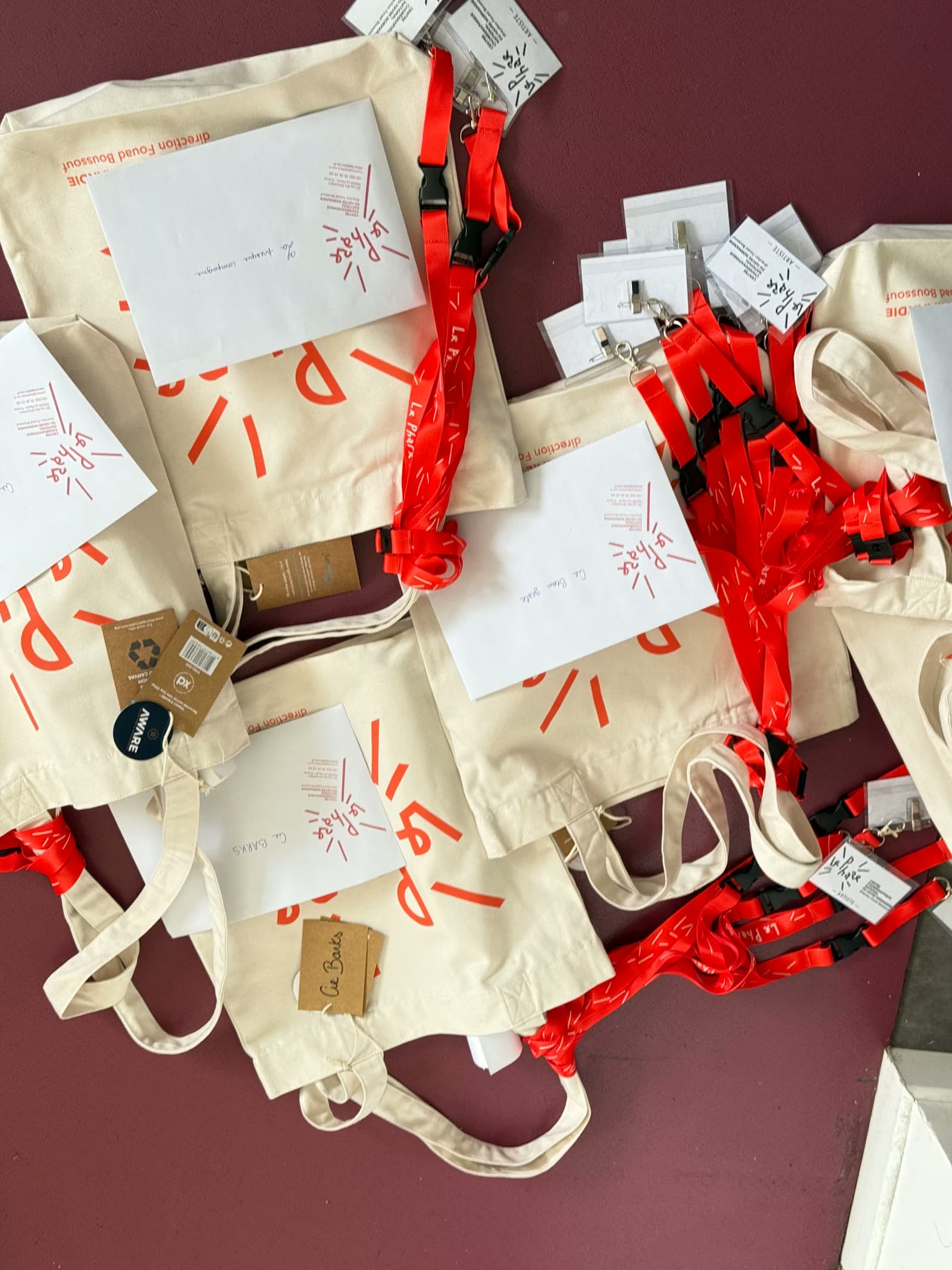 Tote bags, badges et lanyards du Phare préparés avant un événement